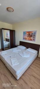 Un dormitorio con una cama grande con sábanas blancas. en Sunrise Apartment 14, en Obzor