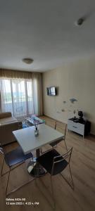 Una sala de estar con una mesa y sillas blancas. en Sunrise Apartment 14, en Obzor