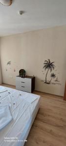1 dormitorio con 1 cama y una palmera en la pared en Sunrise Apartment 14, en Obzor