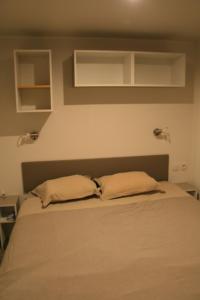 ein Schlafzimmer mit einem Bett mit zwei Kissen darauf in der Unterkunft mobil home premium 6 personnes très confortable climatisé in Montagnac