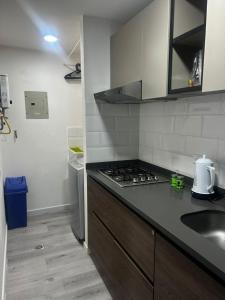a kitchen with a sink and a stove top oven at Aptosvacacionales Medellín in Medellín