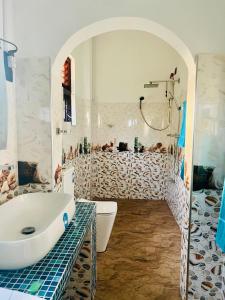 a bathroom with a tub and a toilet and a sink at King Royal - Tangalle in Tangalle