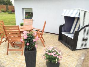 a patio with chairs and a table and flowers at Ferienhaus in Schwarzhausen in Schwarzhausen