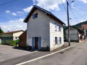 ServanceにあるCharmante Maison Les Volets Bleusの通り沿いにある白い建物