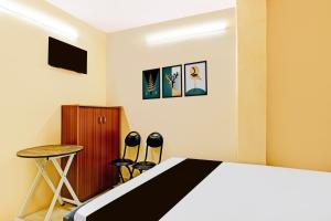 a bedroom with a bed and a table and stools at Hotel O Moontara in Faridabad