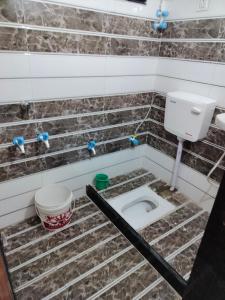 a dirty bathroom with a toilet in the floor at Choudhary Guest House in Khātu