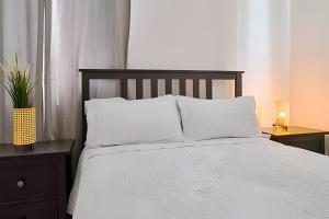 una camera da letto con un letto con lenzuola e cuscini bianchi di Caribbean Getaway Paradise Villa a Punta Cana Altre 40 foto