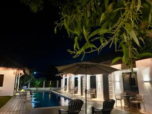 - un parasol à côté de la piscine la nuit dans l'établissement Casa Marga Resort - Panglao, Bohol, à Panglao