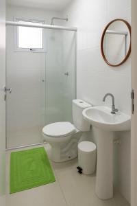 une salle de bain avec toilettes, lavabo et miroir dans l'établissement Apato em Condomínio, à Belém