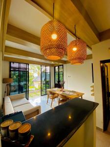 a kitchen and living room with two hanging lights at PARAWIYA Villa in Munduk