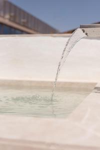 una corriente de agua que se vierte en una piscina en Navas 402 Ático & Pool Alhambra views, en Granada