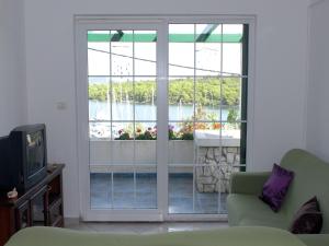 a living room with a couch and a sliding glass door at Holiday Home in Veli Rat near Saharun in Veli Rat