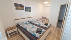 Un dormitorio pequeño con dos camas y una silla. en VIA Apartmany, en Trenčín