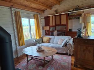a living room with a couch and a table at Petit Chalet en Baie de Somme in Saint-Valery-sur-Somme