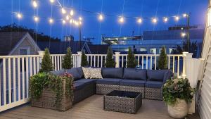 a patio with a blue couch on a balcony at night at Duplex Rooftop at MIT Kendall Sq - 2 FREE Parking in Cambridge