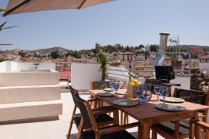 una mesa en un balcón con vistas a la ciudad en Navas 402 Ático & Pool Alhambra views, en Granada