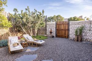 a backyard with two chairs and a stone wall at The Moonlight Yurt in Essaouira