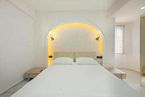 a bedroom with a large white bed with an archway at The B HOUSE in Fethiye +15 photos