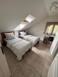 a bedroom with two beds and a skylight at Penzion pod lesem in Most