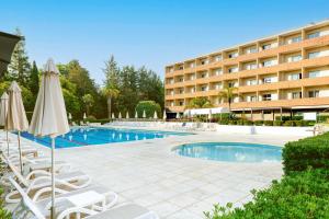 un hôtel avec une piscine dotée de chaises et de parasols dans l'établissement Crowne Plaza Rome St. Peter's by IHG, à Rome