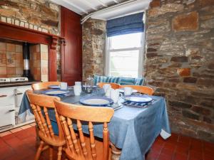 a dining room with a table with chairs and a kitchen at Tregundy Farmhouse in Perranporth
