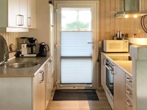 a kitchen with a sink and a window with a blind at 5 star holiday home in Jerup in Jerup