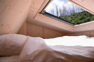 a bed in a tiny house with a window at Tiny House Pioneer 6 - Green Tiny Village Harz in Osterode