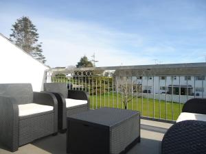 eine Terrasse mit Stühlen und einem Tisch und einem Gebäude in der Unterkunft 2 Bed Cottage Abersoch - close to beach and village - Pet Free in Abersoch