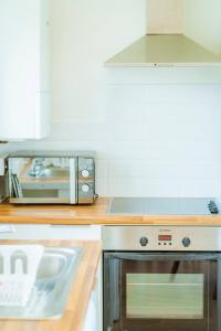 eine Küche mit Toaster und Mikrowelle in der Unterkunft 2 Bed Cottage Abersoch - close to beach and village - Pet Free in Abersoch + 31 Fotos