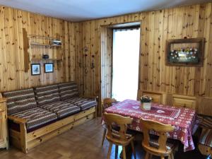 a room with a bed and a table and a window at Casa Solidea in Moena