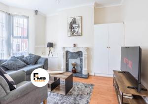 リバプールにあるFree Parking, 4 Bed, 2 Bath House, Long Term Stay Savings, Contractors, Near Anfieldのソファとテレビのあるリビングルーム