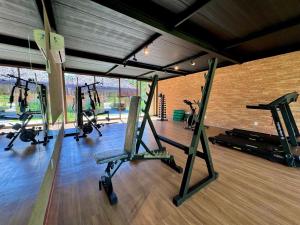 a gym with several tread machines in a room at Makaii Studio B005 - Villa Naluri in Japaratinga