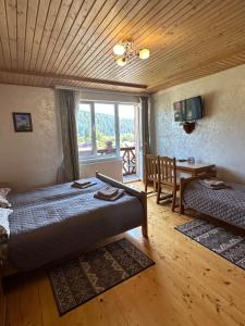 a bedroom with two beds and a table and a window at Гостинний двір Стефані in Tatariv
