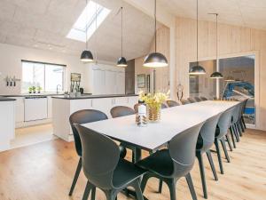 a dining room and kitchen with a large table and chairs at 5 star holiday home in Fjerritslev in Fjerritslev