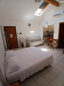 a bedroom with a white bed and a living room at AL VISTA CIELO in Forlì