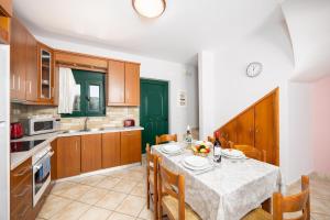a kitchen with a table and chairs and a kitchen with green doors at Villa Valio in Dhrapanítika