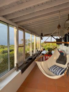 a hammock in a room with windows at Pico Sereno in Santana