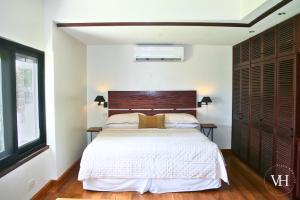 Un dormitorio con una cama grande con cabecero de madera. en The Bougainvillea Studio at Villa Horizon, en Rodney Bay Village
