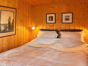a bedroom with a bed in a wooden wall at 9 person holiday home in Vesterøy in Hauge