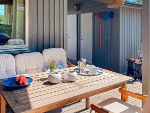 a wooden table sitting on a patio with at 9 person holiday home in Vesterøy in Hauge