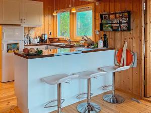 a kitchen with a counter and stools in a room at 9 person holiday home in Vesterøy in Hauge
