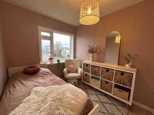 a bedroom with a bed and a mirror and a chair at Stylish 3BR Apt Near Downtown in Reykjavík