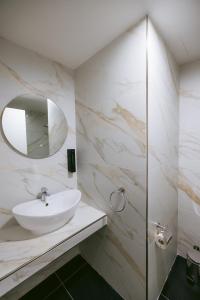 a white bathroom with a sink and a mirror at Las Vegas Resort Malta in St. Julianʼs +20 photos