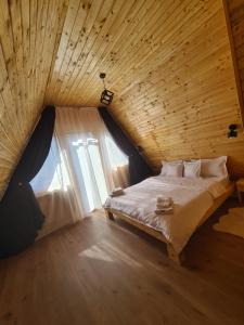 a bedroom with a large bed with a window at A frame Ina și Cristi in Tîrsa