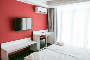 a red room with two beds and a tv on the wall at Las Vegas Resort Malta in St. Julianʼs