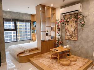 a bedroom with a bed and a table in it at Phong Linh Homestay 30 Căn hộ Vinhomes Grand Park giá tốt nhà đẹp in Long Bình