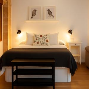 sypialnia z łóżkiem z dwoma obrazami na ścianie w obiekcie Barbacana, dieciocho w mieście Baeza