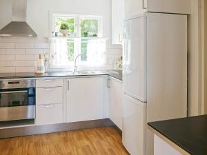 a white kitchen with a refrigerator and a sink at 8 person holiday home in Hyltebruk in Hyltebruk