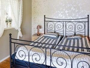 a bedroom with a bed with a wrought iron headboard at 8 person holiday home in Hyltebruk in Hyltebruk