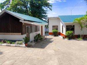 a building with a blue roof and a patio at Moshi Green Lodge in Moshi +14 photos